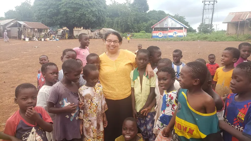 Niños reunidos al aire libre en un evento comunitario de Dorcas Foundation.