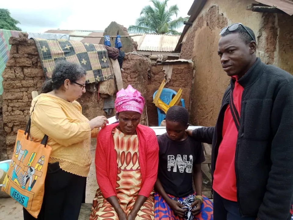 Una voluntaria de Dorcas Foundation saludando a una familia durante una visita comunitaria.